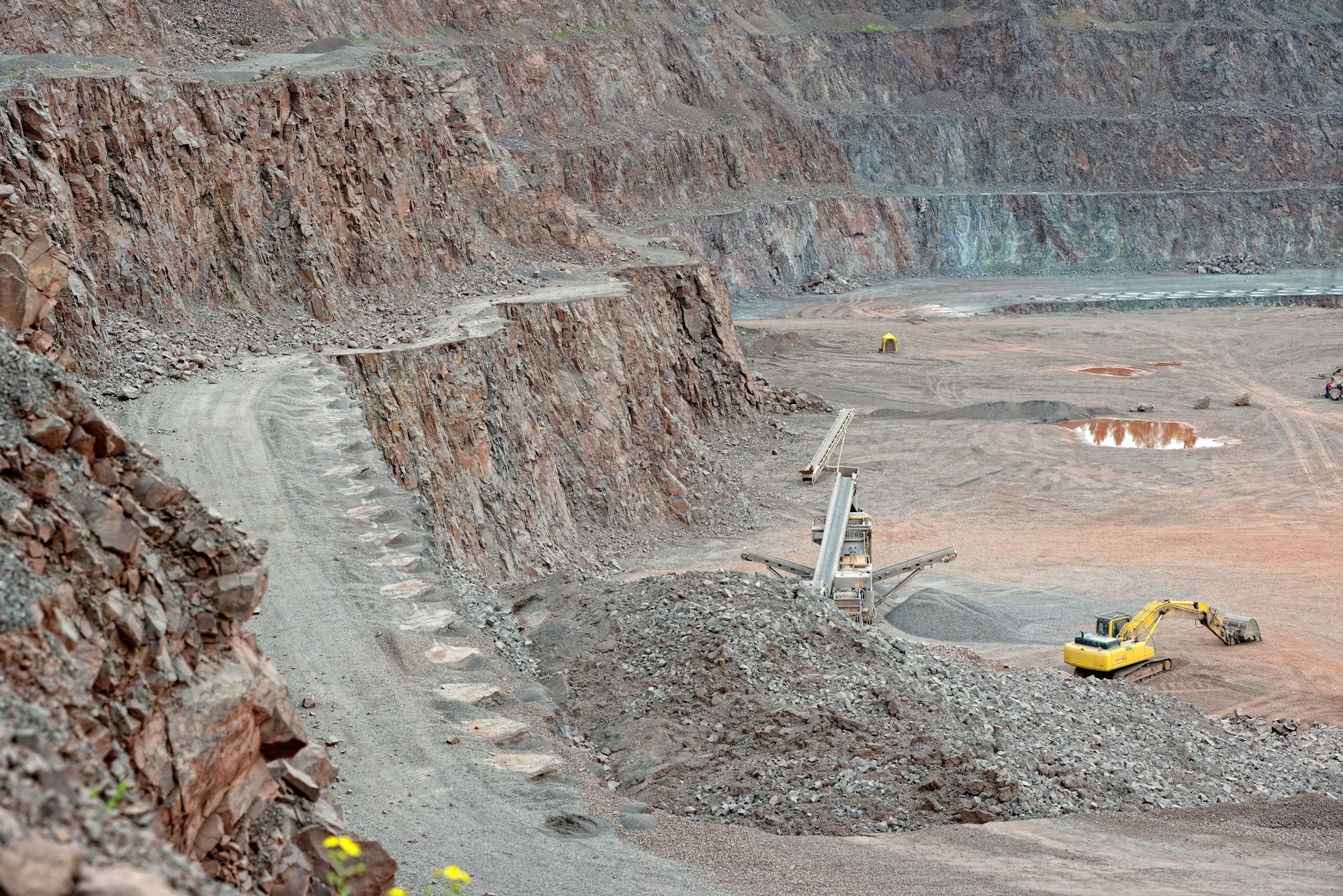 Home 13 Stone crusher and excavator in a porphyry quarry. mining industry