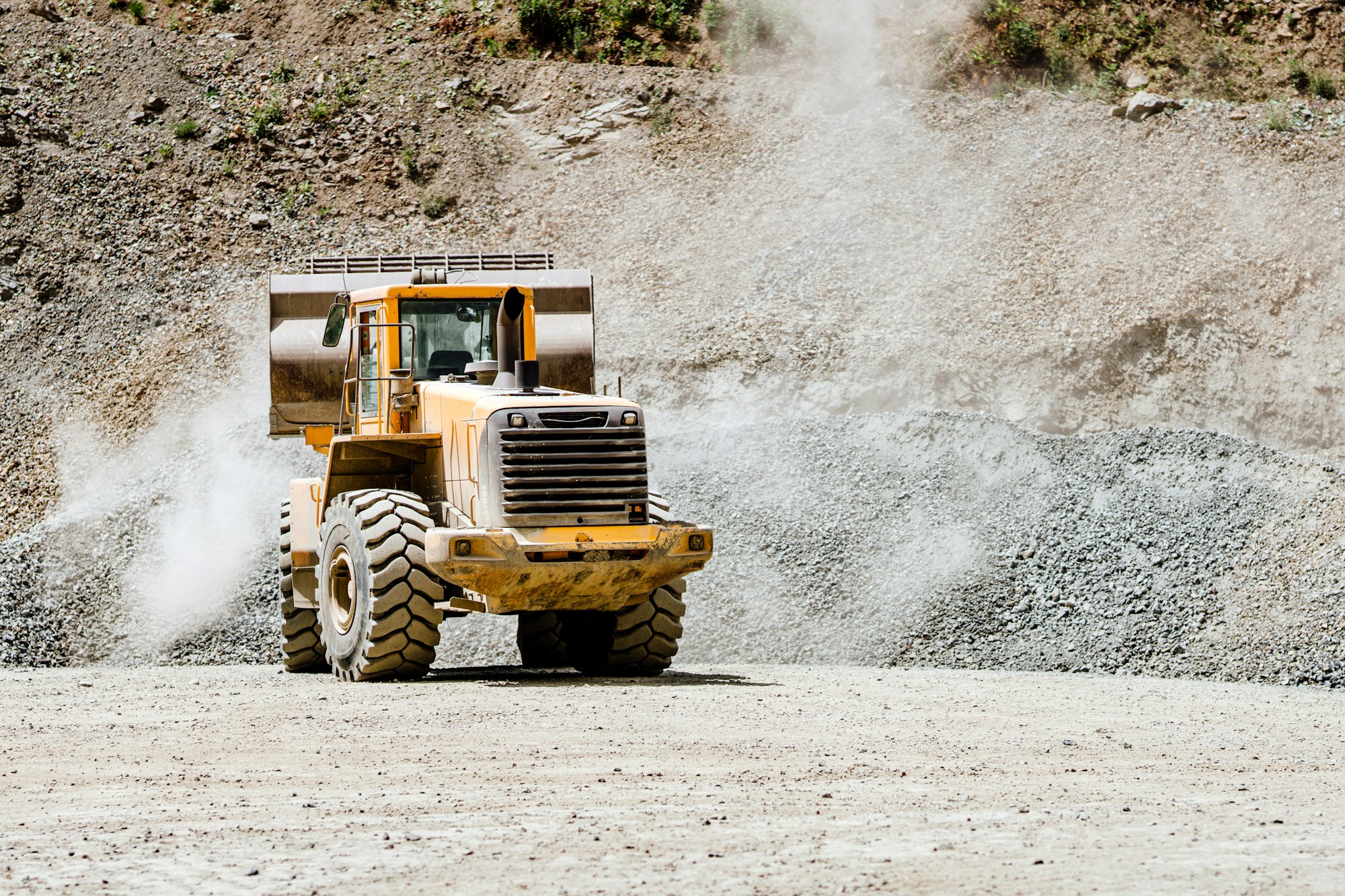 About Us 4 Wheel loader machine loading rocks in the open-mine, iron ore mining.